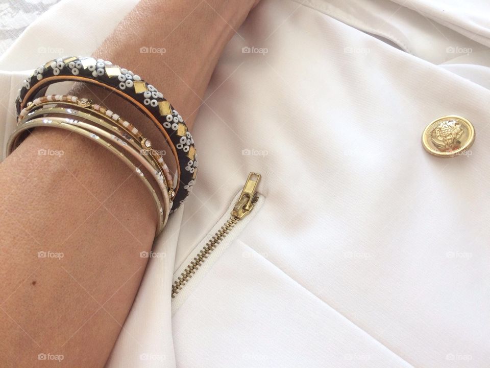 Person's hand with bracelet on blazer