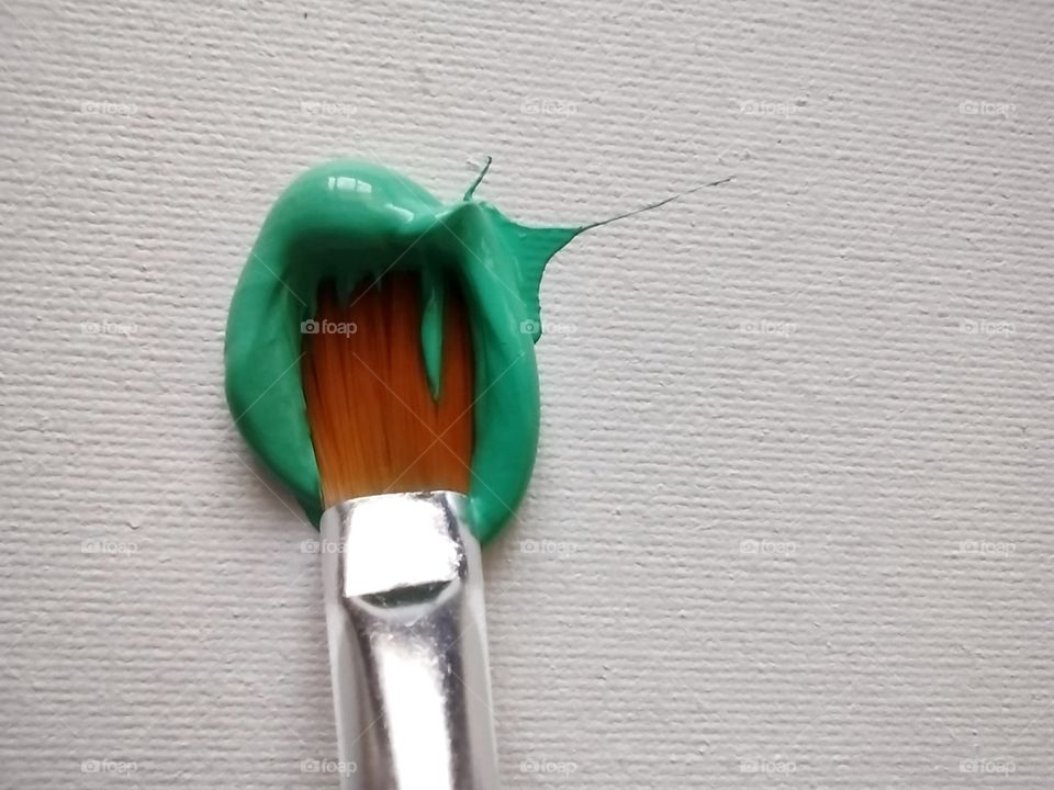 Unfiltered, beautiful, lovely close-up of green paint and a paint brush