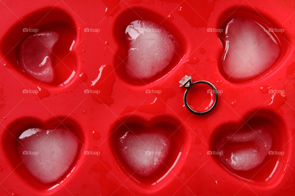 Diamond engagement ring among heart shaped ice cubes