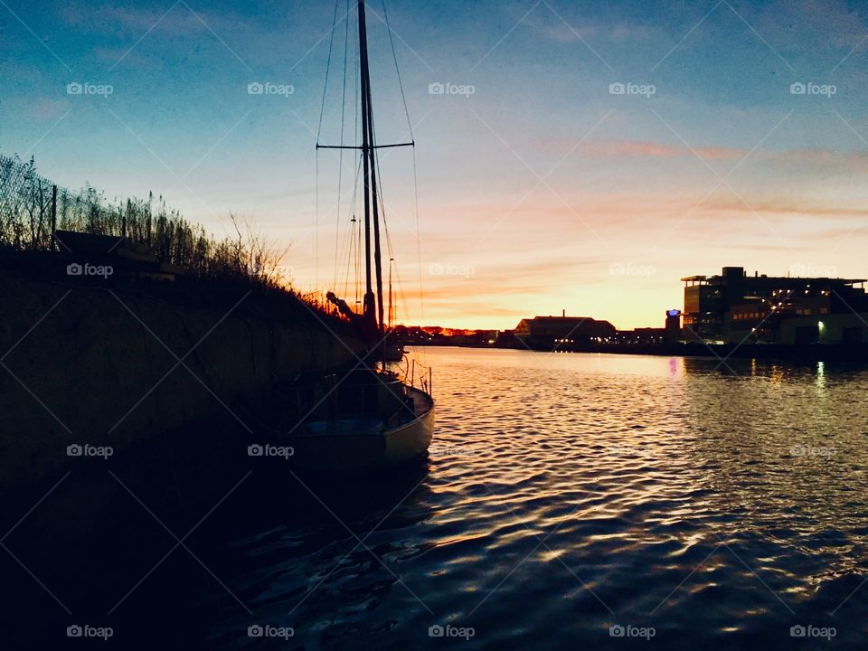 Sunset over Newtown Creek in Long Island City, Queens, NY as seen from our sailboat, the “Salvation” in 2018. The setting sun is casting beautiful colorful reflections upon the water of the East River. Hypnotic Productions