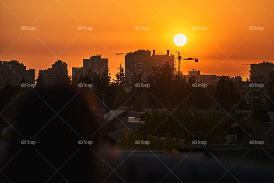 Person watching the sunset of the city