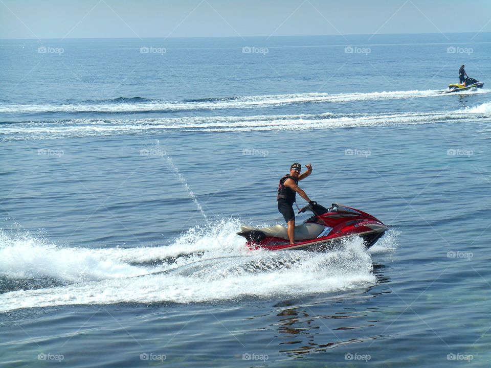 smiling men on a water bike riding on a sea summer activities