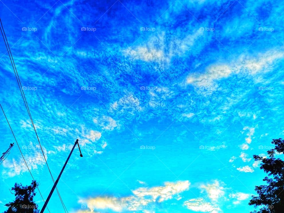 The sky with lots of clouds and trees looks so peaceful and serene. It's like nature's own masterpiece up there! 🌳☁️