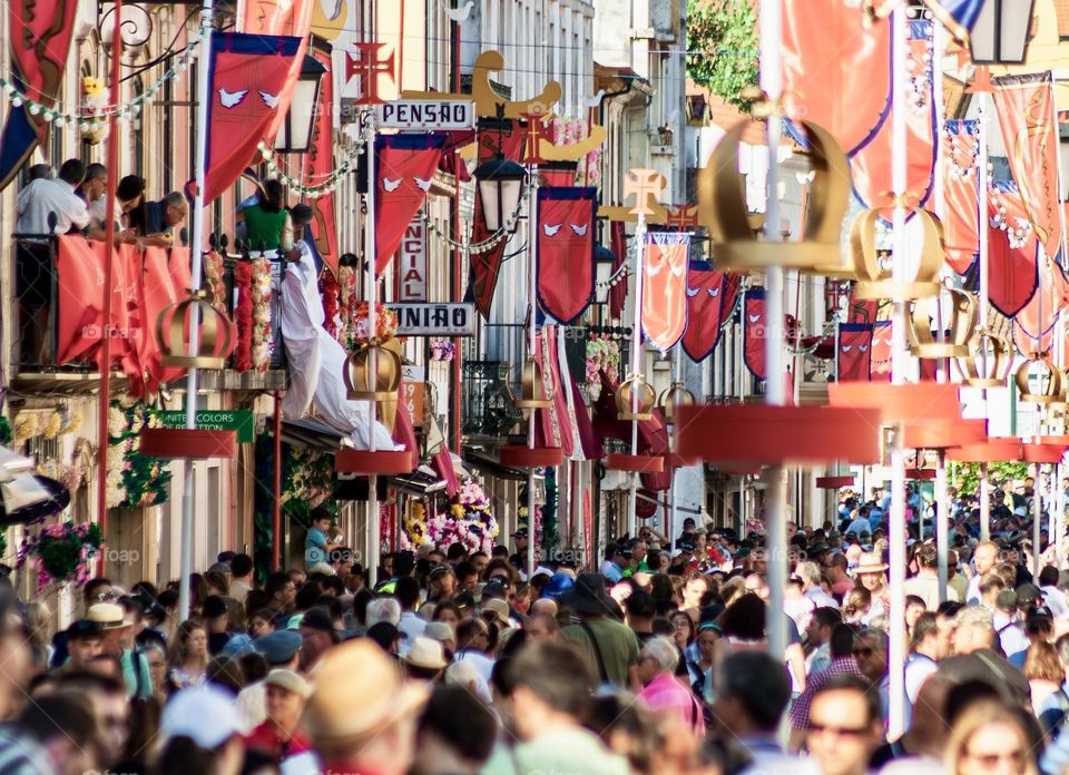 A bustling crowd of people fill the city streets of Tomar, Portugal during a festival