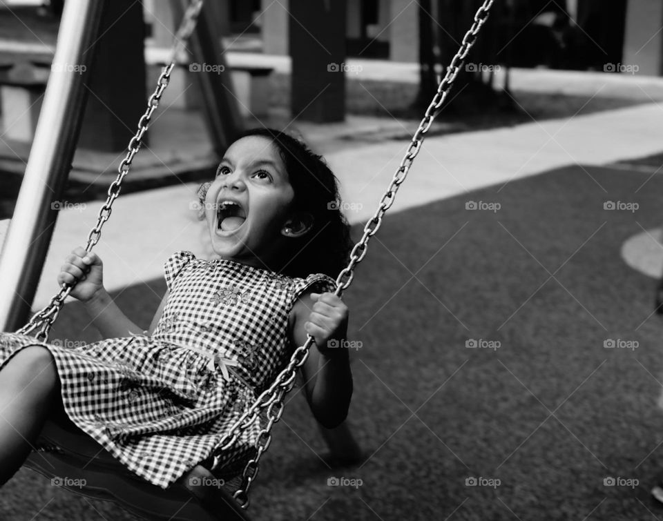 Angry girl swinging on swing 