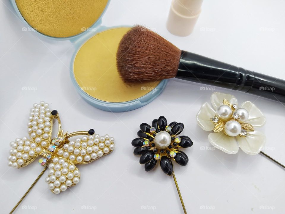 Compact powder, makeup brush and brooch decoration isolated on white background
