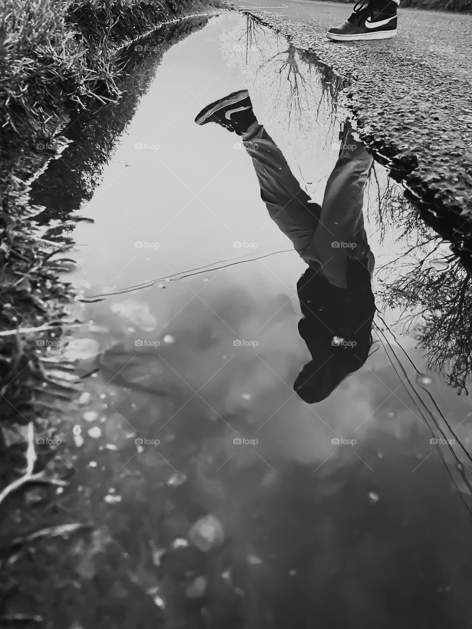 Person reflected in puddle