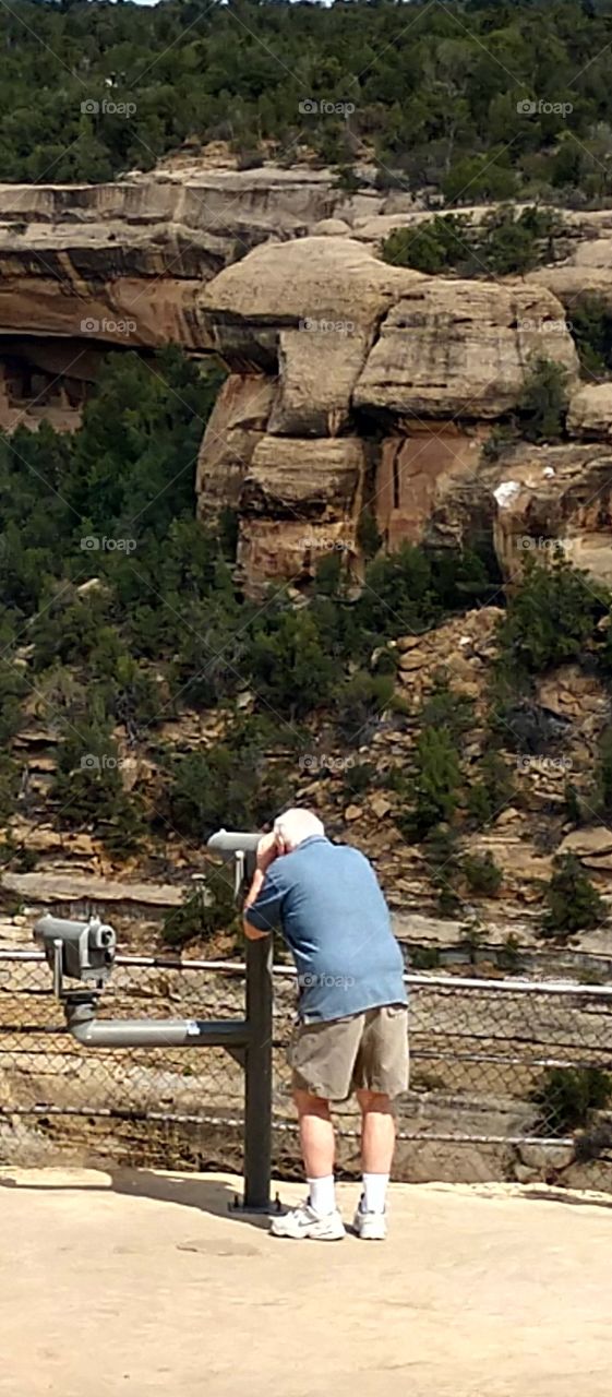 Tourist looking thru telescope