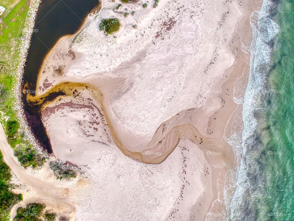 Aerial photo of a small creek entering the ocean