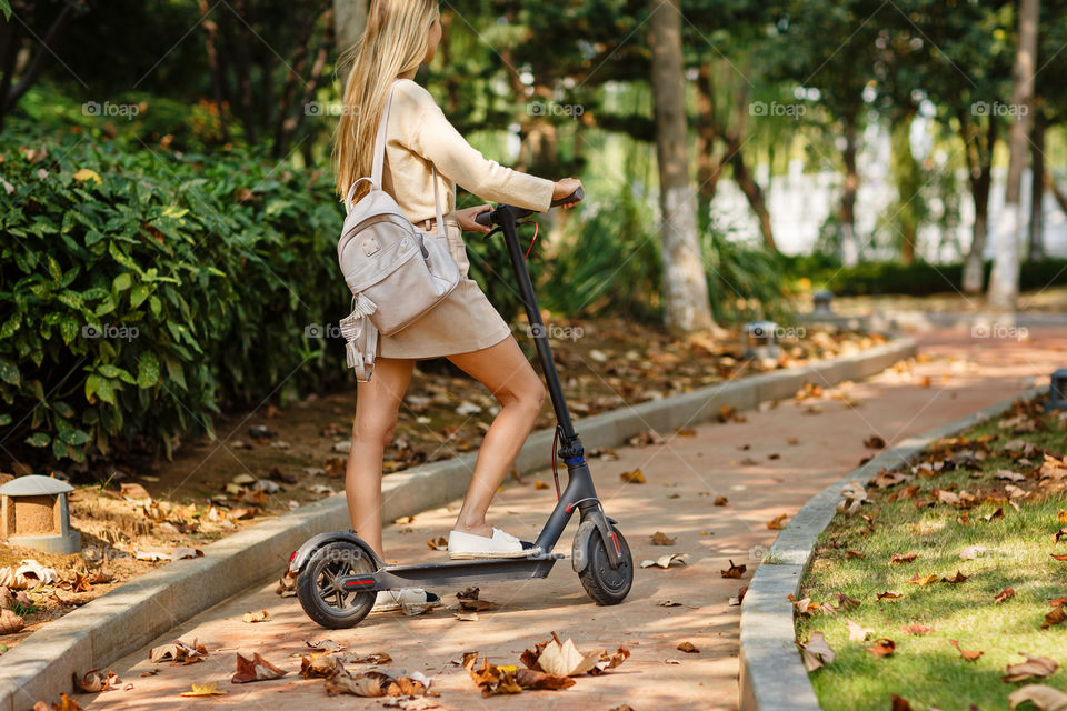 Woman using electric scooter outdoor 