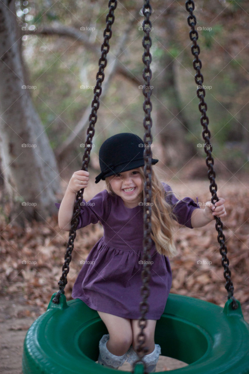 Girl playing on tire swing