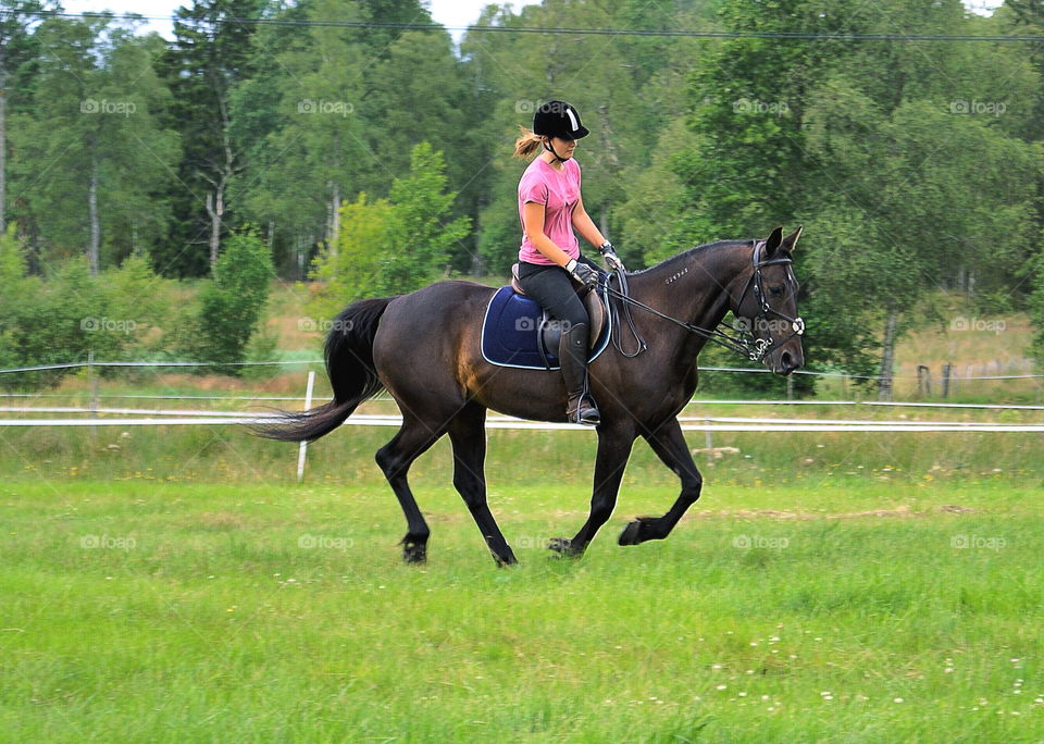 Young woman riding on horse