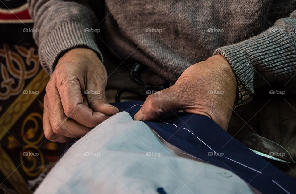 The man opens his small shop everyday and starts the sewing and embroidery of table mattresses and wall art made of textile.