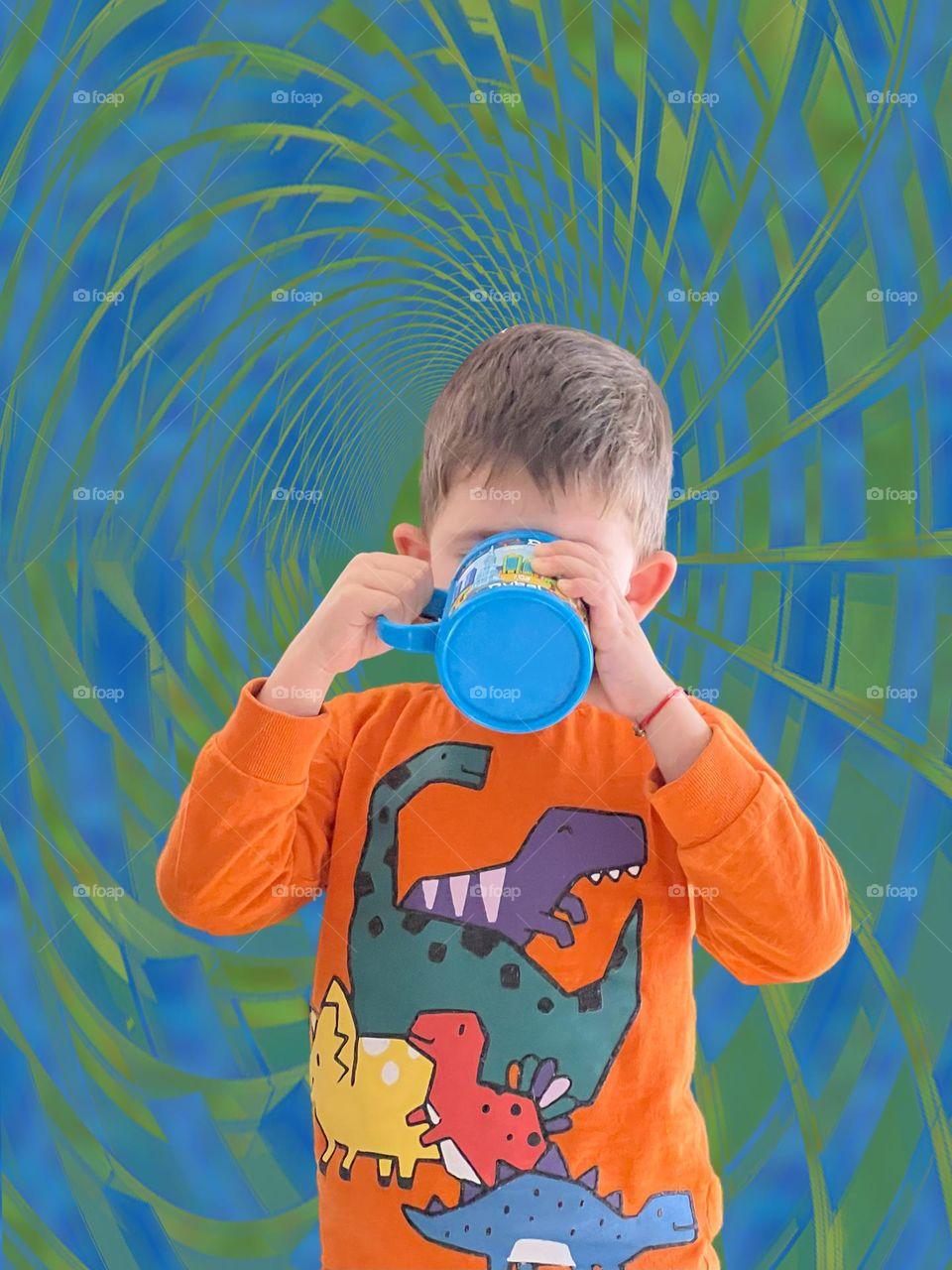 Little boy drinking water of colourful mug