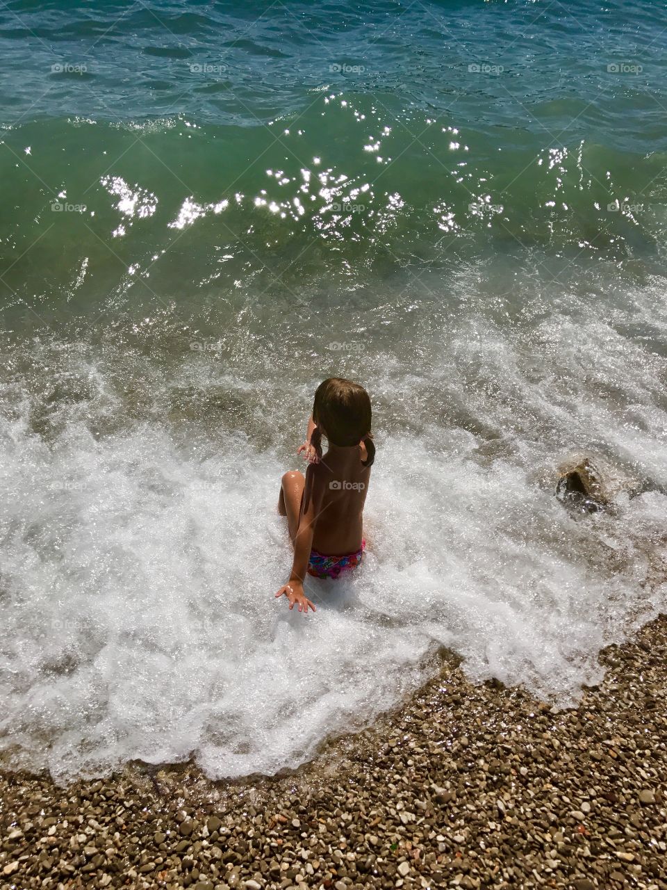 Little girl is playing with waves 