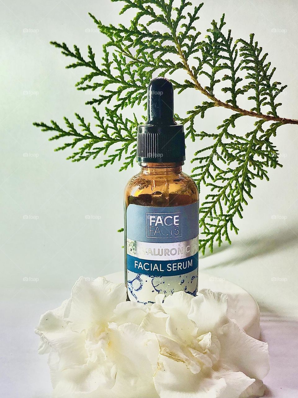Face serum picture with white and green drops 
