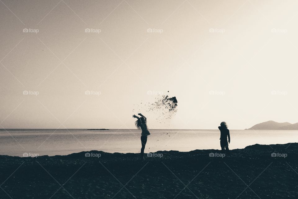 Kids throwing seaweed on the beach