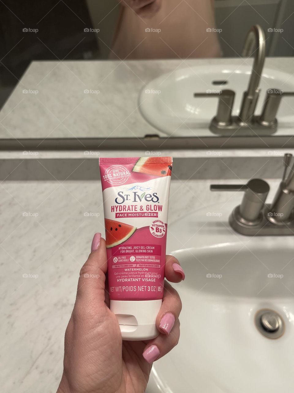 Female’s hand with St. Ives face cream