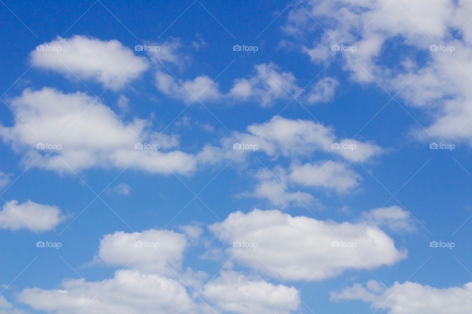 Puffy white clouds against a vivid blue sky