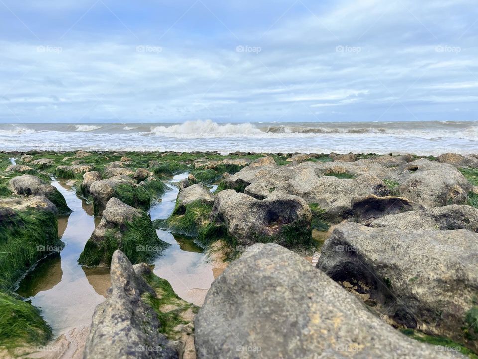 Praia de coqueirinhos na Paraíba. Aqui céu, areia, mar e rochas se misturam em um mosaico de cores e formas fluidas. 