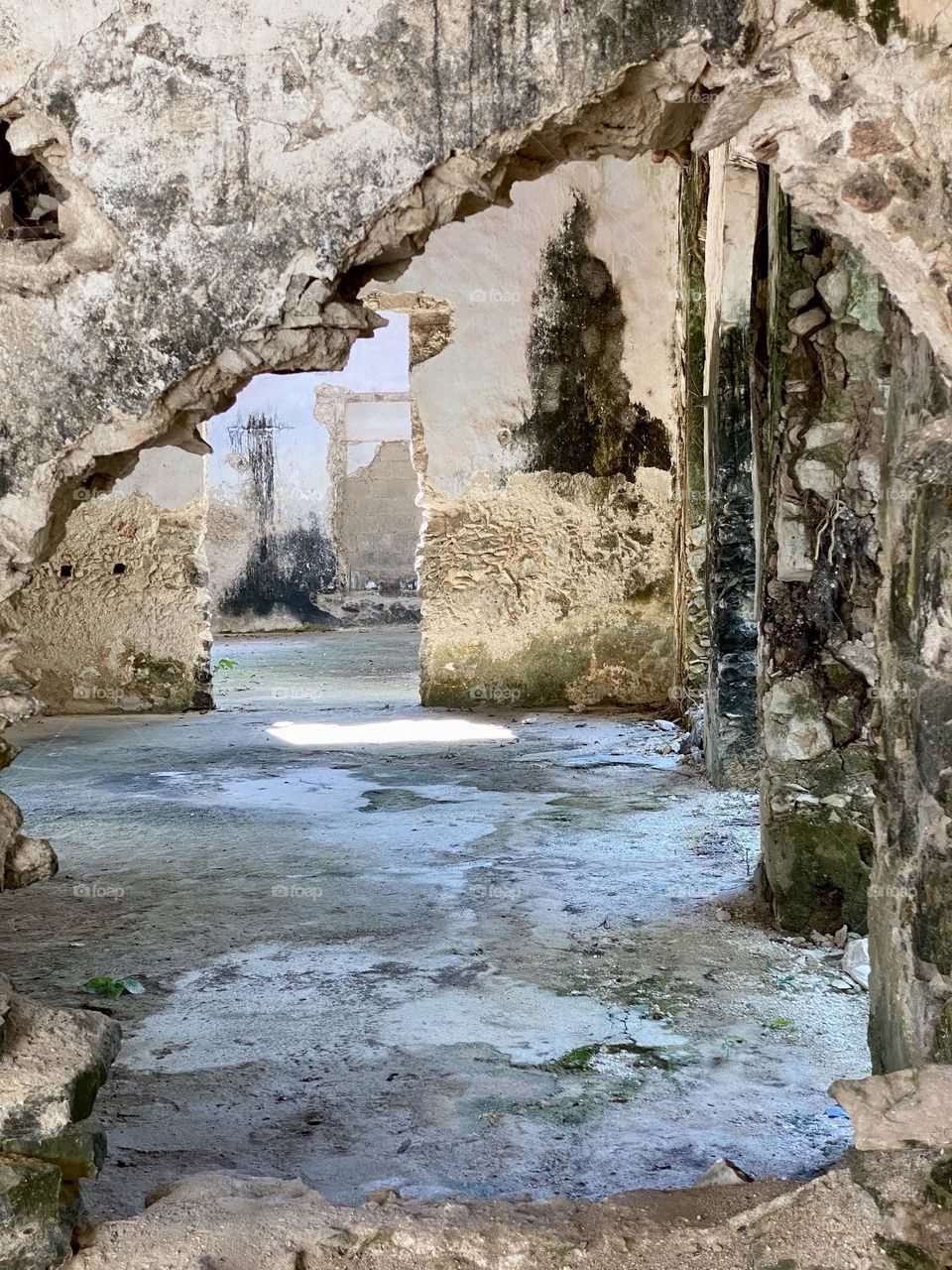 Looking through a hole in the wall of an old Spanish hacienda