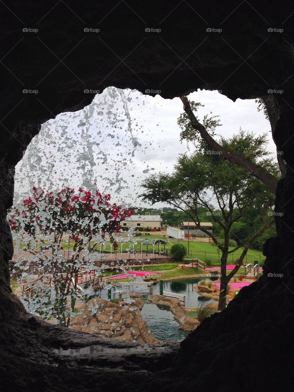 Looking out. Hole in man made cave wall looking out at a waterfall.....mini golf course