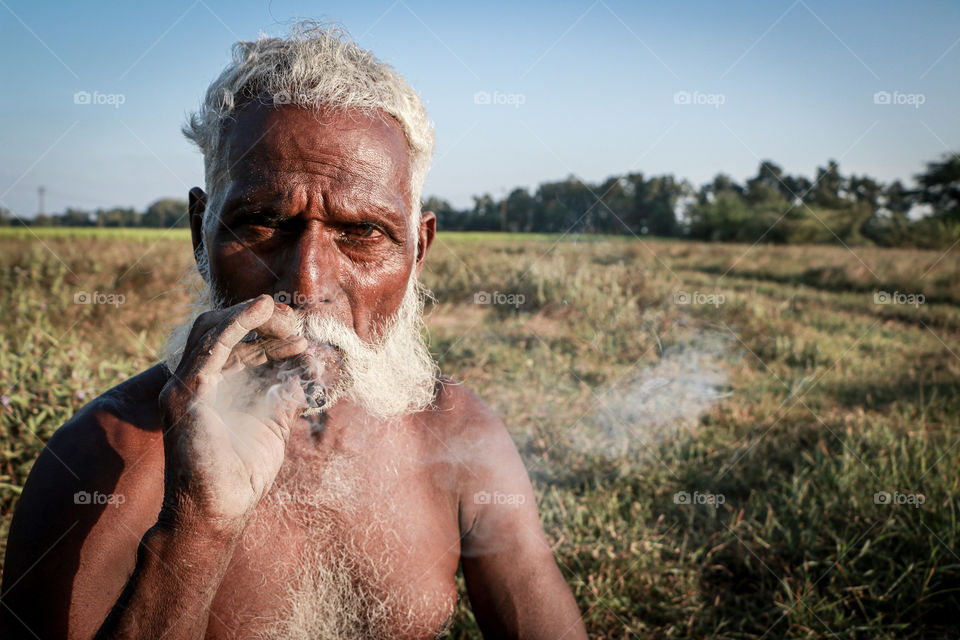 A story of an old men who smoking cigarette bravely in between his work time