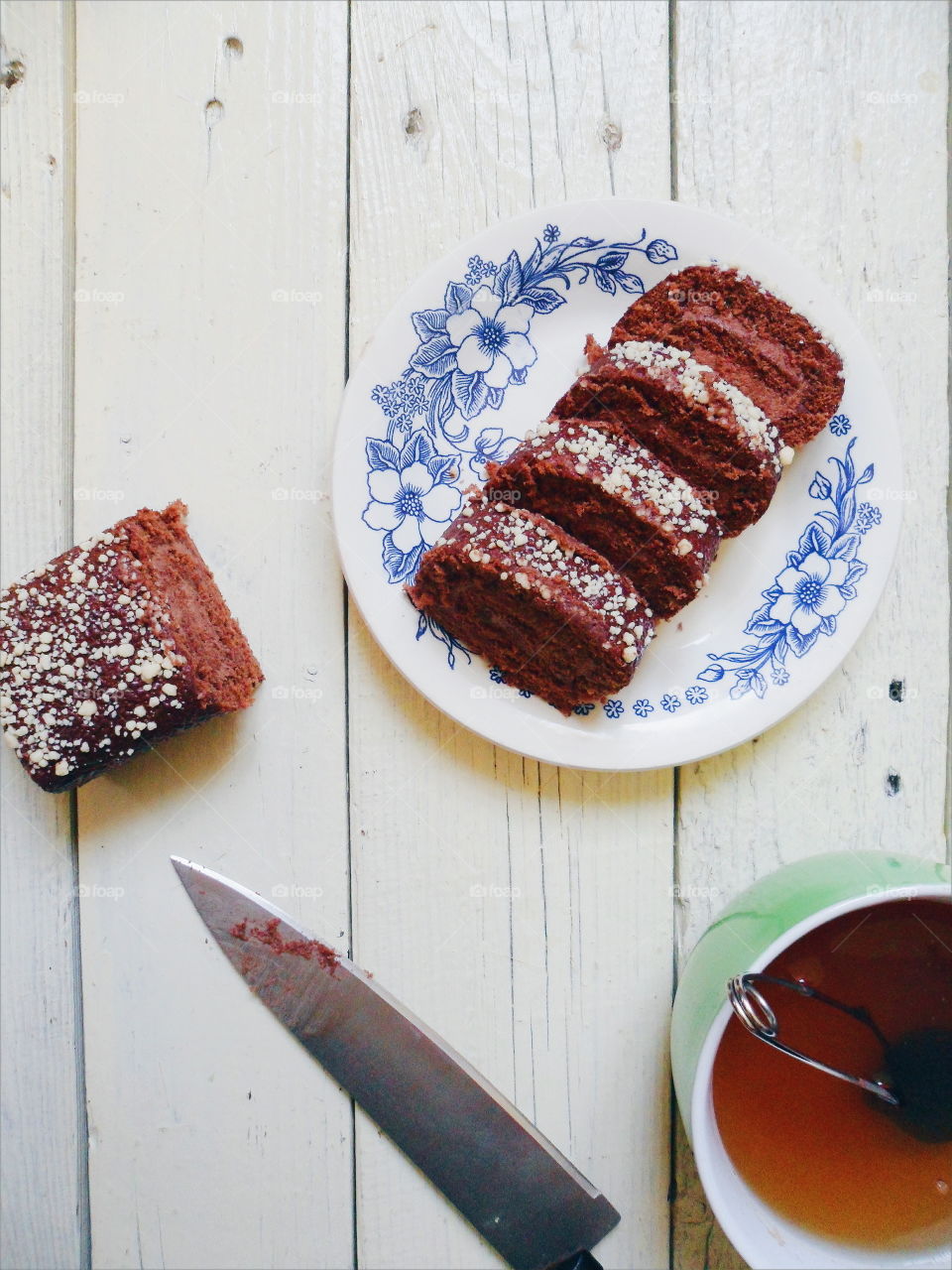 chocolate roll and a cup of black tea on a white background