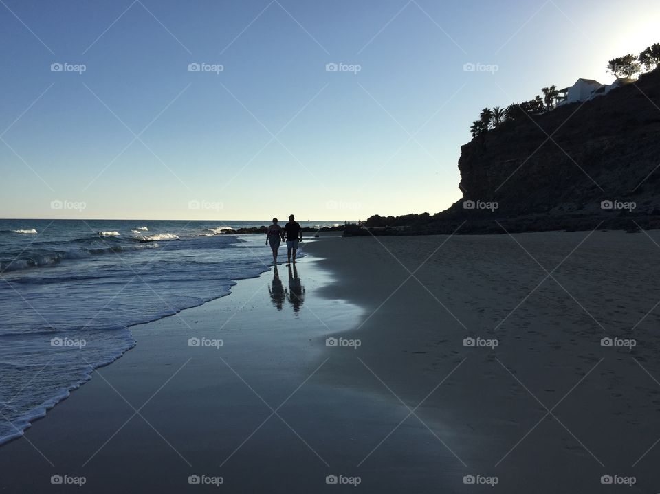 Old couple walking on a beach