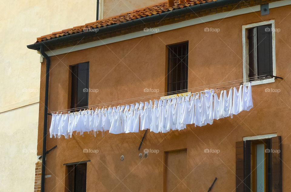 White laundry drying on colorful house