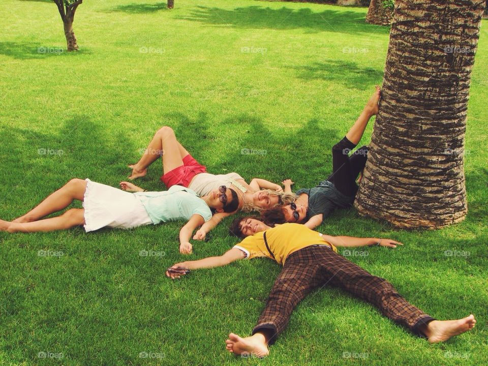 Happy friends lying on the grass 