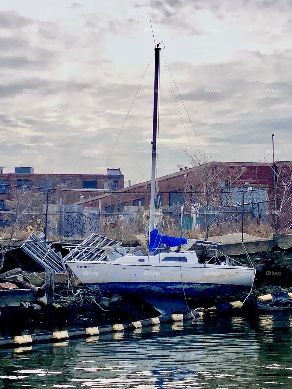 A sailboat in the waters of the East River at Newtown Creek in Long Island City, Queens, New York on an overcast late afternoon in 2018. Hypnotic Productions