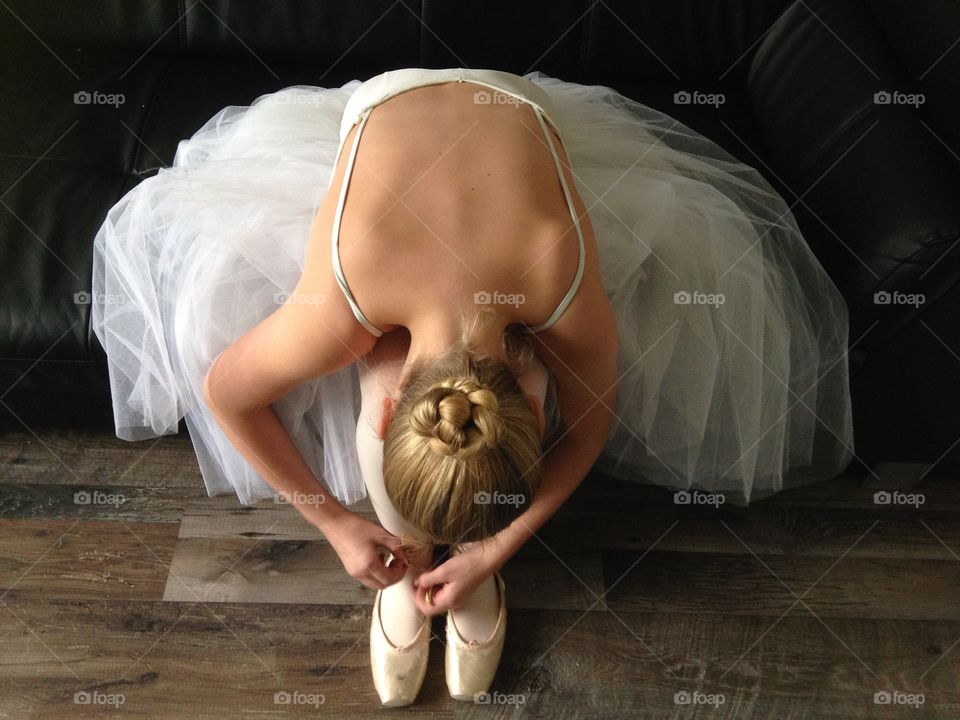 Ballerina busy with her shoes