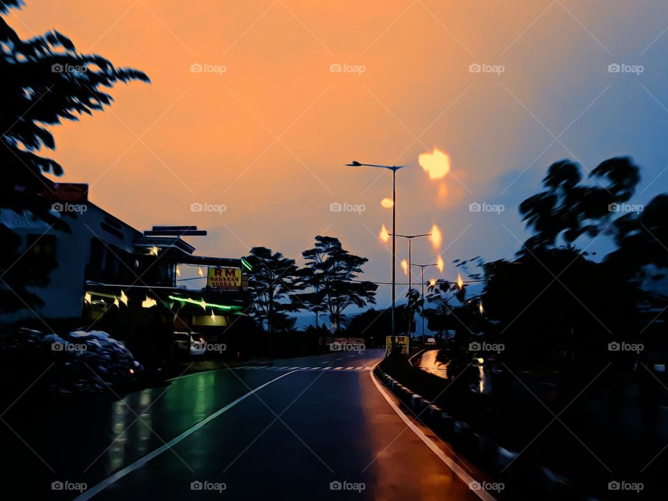 Night view of the highway after the rain, the surface of the road reflects tha light of the lamp, street lighting is shimmering, the road becomes a light mirror, the road is deserted, there are almost no vehicles,