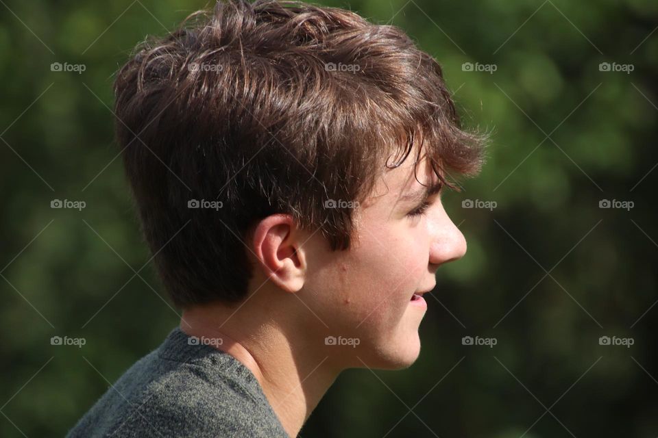 Boy with short brown hair outdoors 