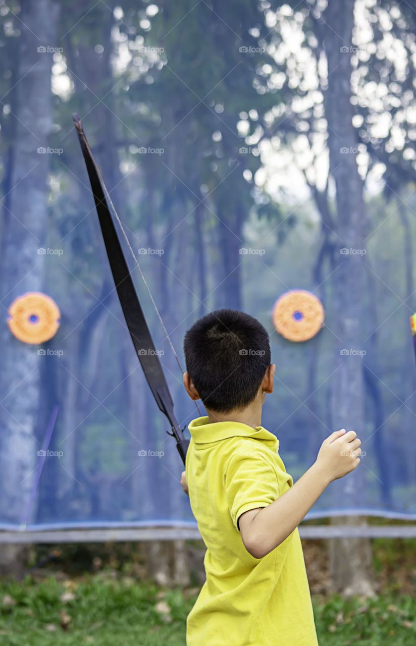 Asian boys are archery in camp adventure.