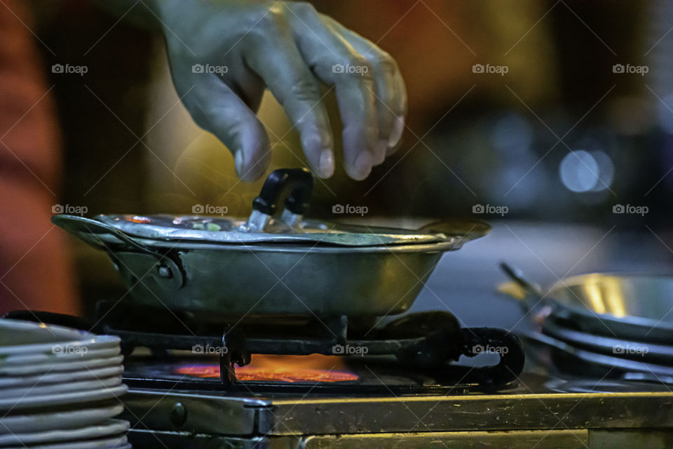 Stainless steel pan on the stove with a yellow flame.