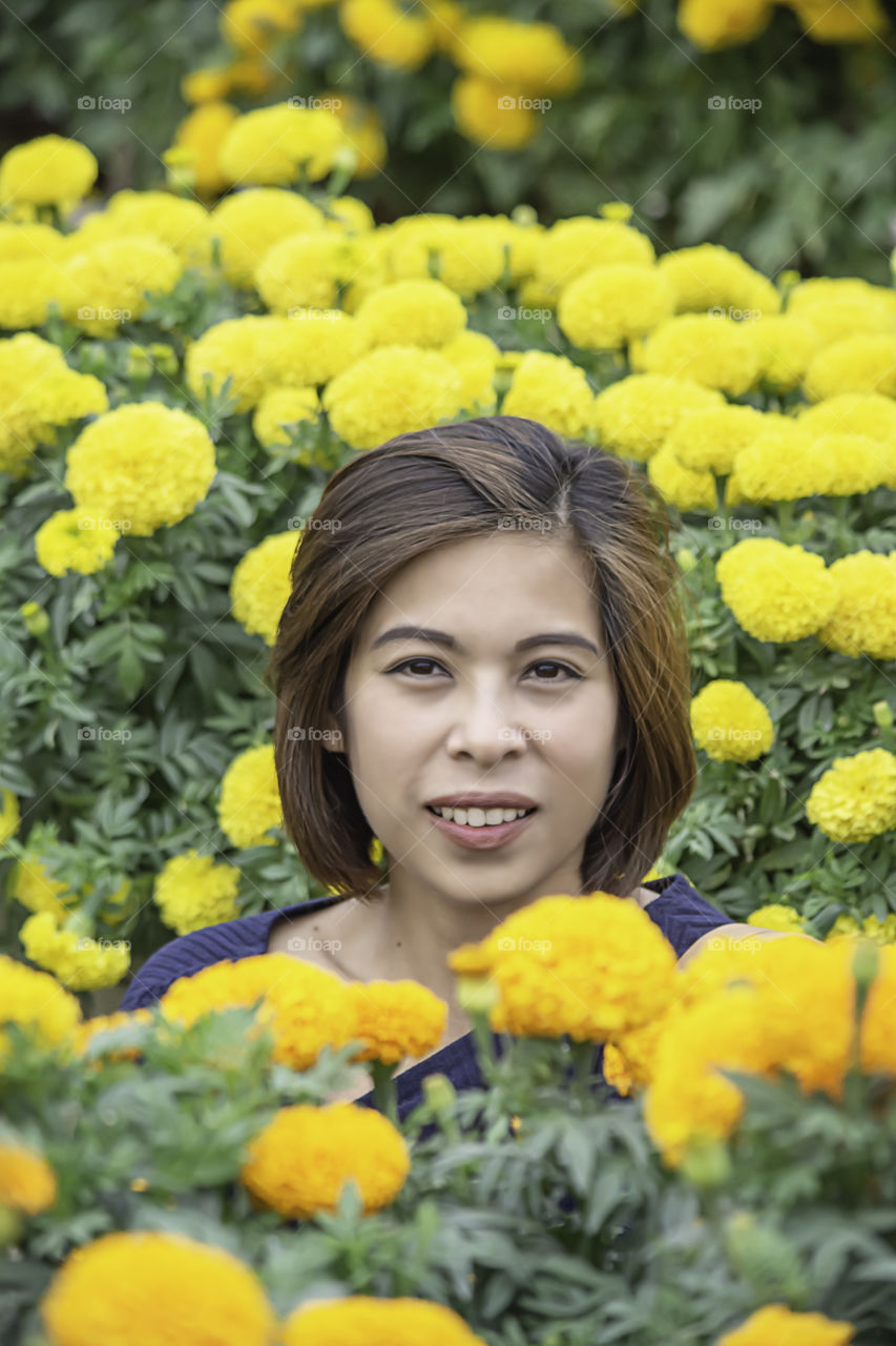 Woman in Yellow Marigold flowers garden or Tagetes erecta in garden