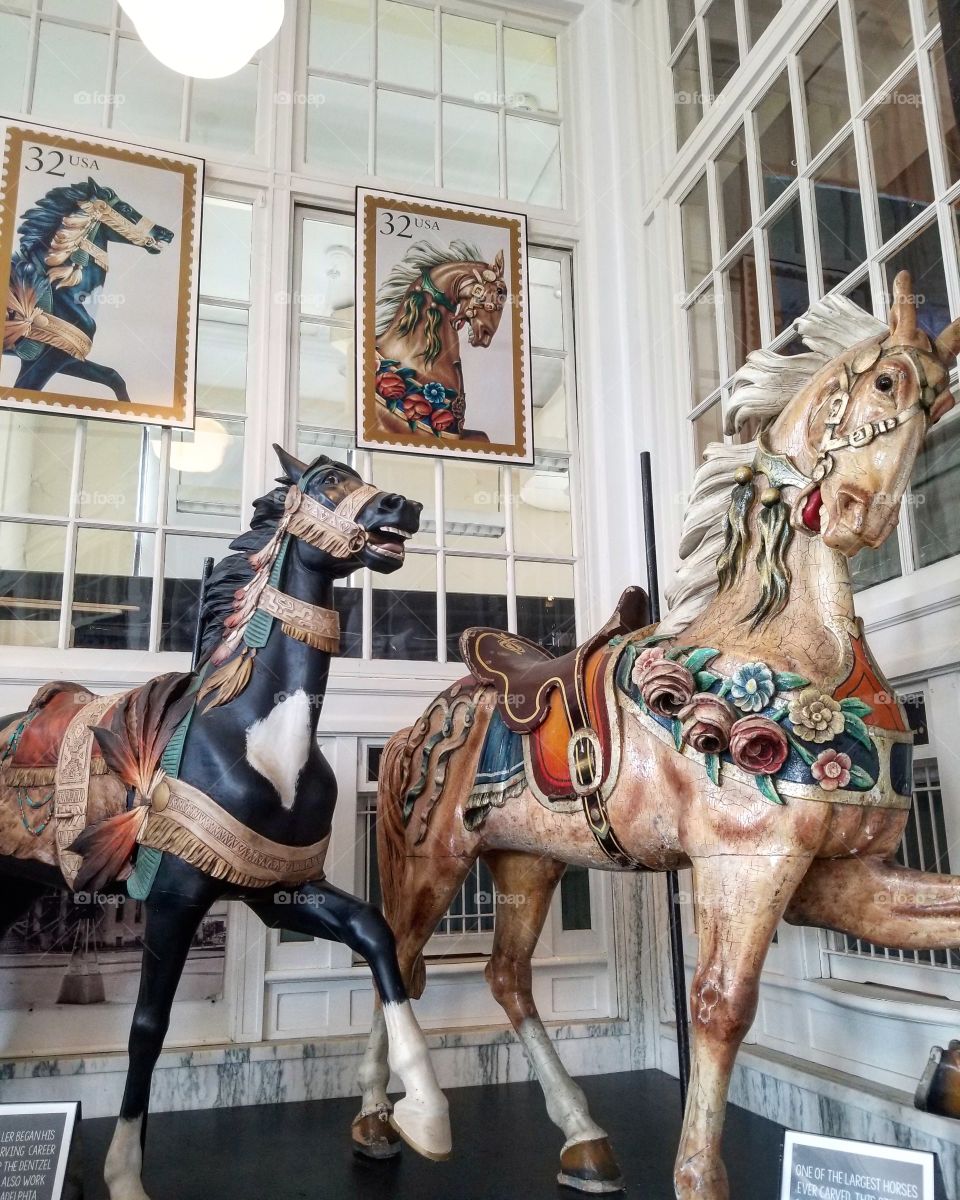 A pair of vintage carved wood carousel horses in a museum in Sandusky, Ohio