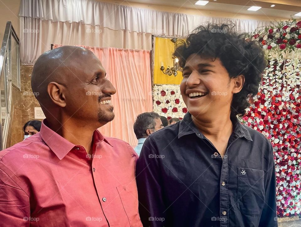 Portrait of two men with full hair and one is bald