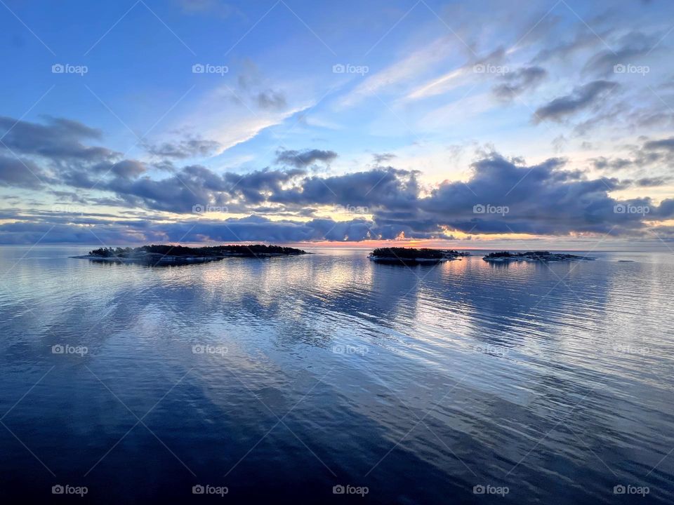 Beautiful tranquil sunrise landscape over the sea water surface with dark clouds 