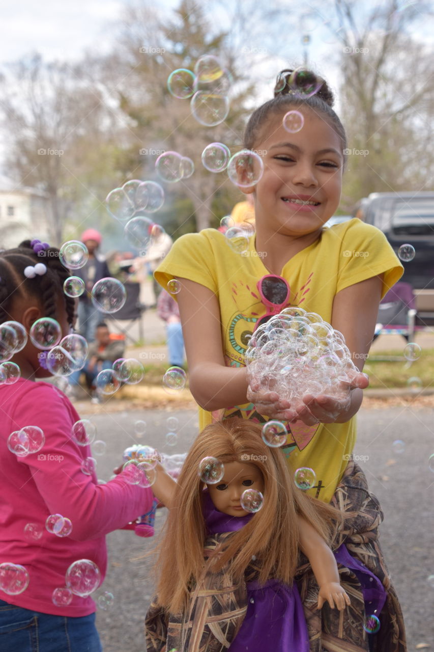 Close-up of a smiling girl with soap bubbles
