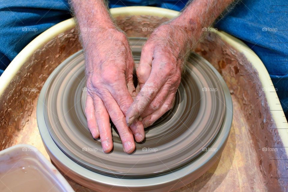 An older craftsman showing his pottery making skills. 