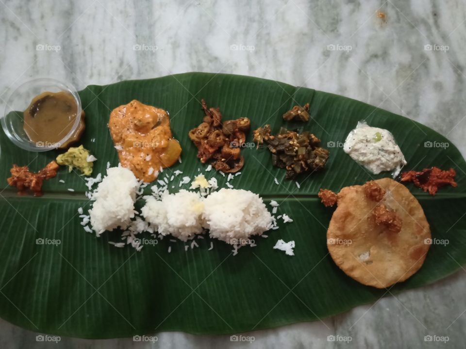 Indian Home Food includes Rice, Poori, Curries, Sambar, etc