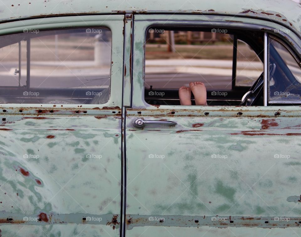 Tiny Feet Peeking Out the Antique Car Door Window 