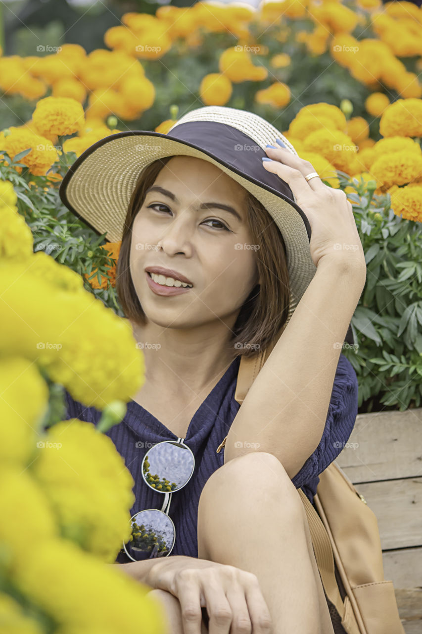 Woman in Yellow Marigold flowers garden or Tagetes erecta in garden