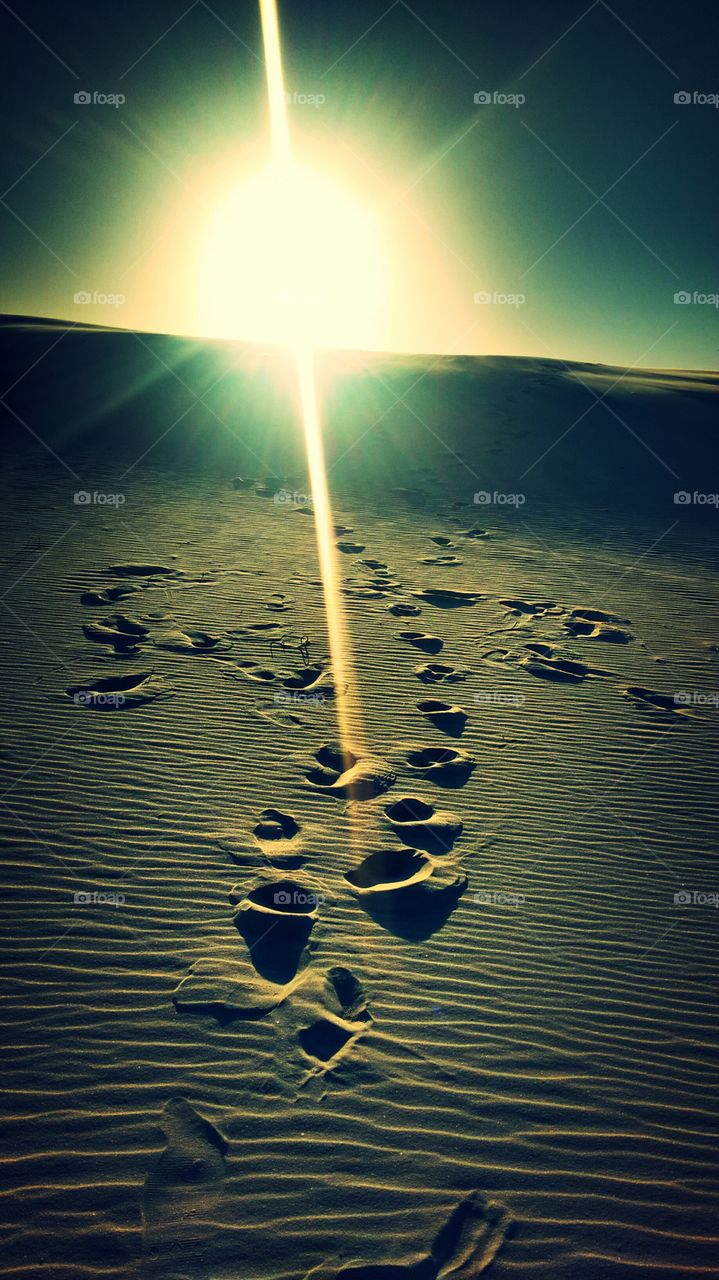 Passos na areia das dunas no por do sol na praia