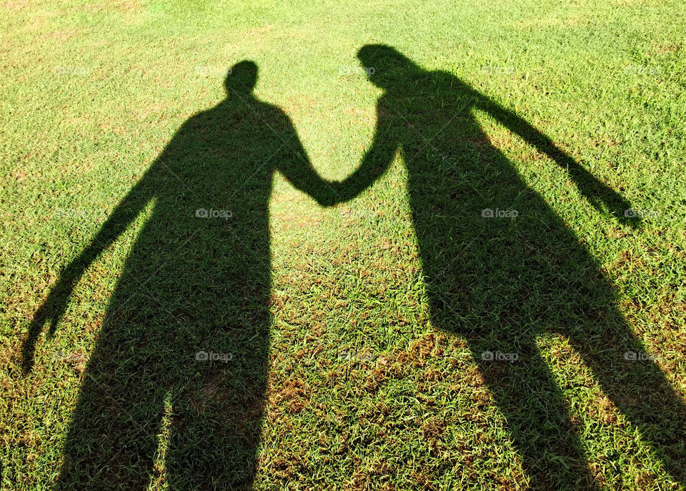 A couples shadow in the lawn