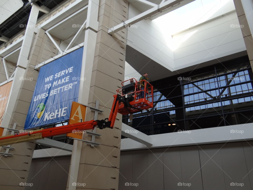 Working Hard. Men in giant boom lift, working. 