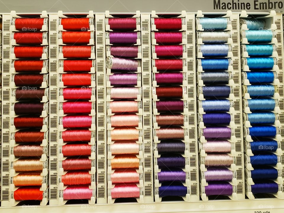 Rows of colorful spools of thread